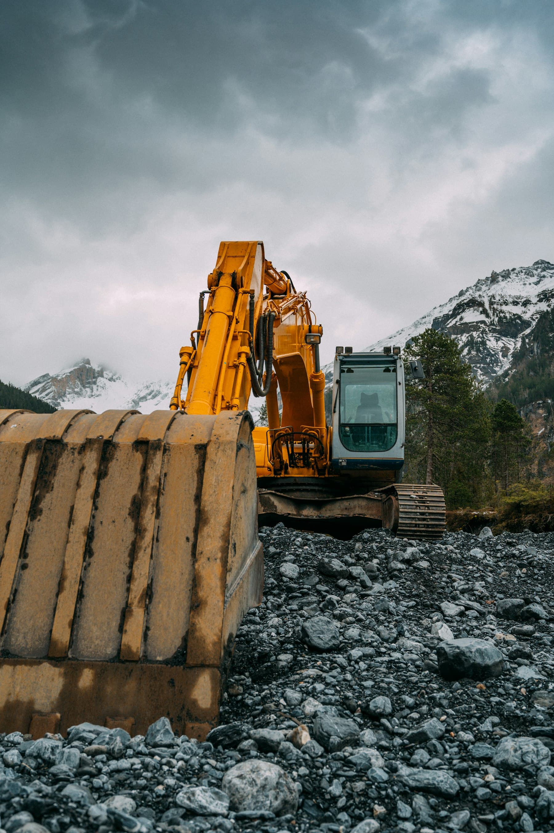 Gravemaskin i arbeid i steinete terreng